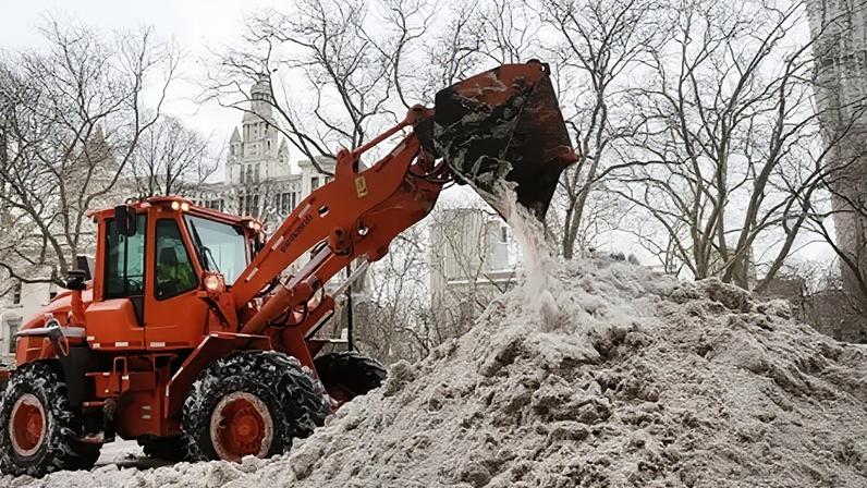 City crews pile snow outside New York City Hall.
