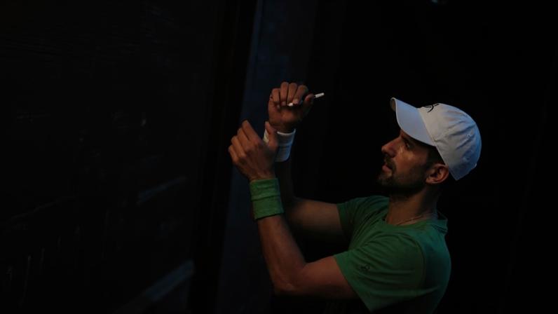Novak Djokovic autografa bola de fã no Australian Open (Foto: William WEST / AFP)