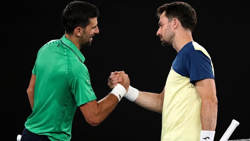 Novak Djokovic cumprimenta Pedro Martínez após a partida do Australian Open, em Melbourne, em 19 de janeiro de 2026. (Foto: David Gray/AFP)