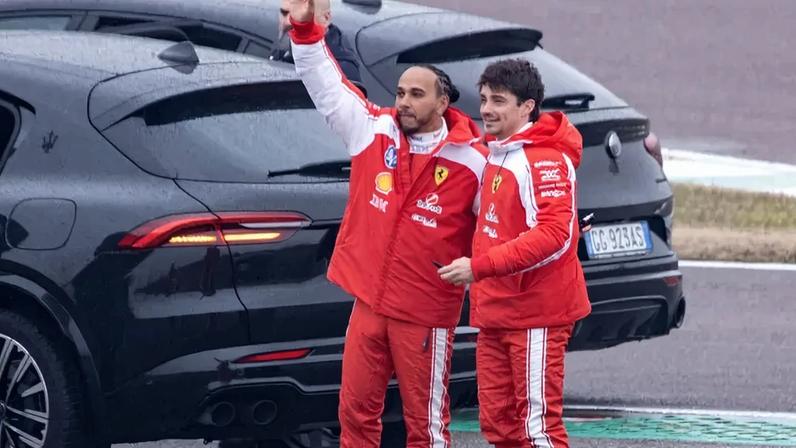 Lewis Hamilton e Charles Leclerc acenam para fãs após testarem a nova Ferrari SF-26 em Fiorano, em 23 de janeiro de 2026 (Foto: Federico Scoppa/AFP)
