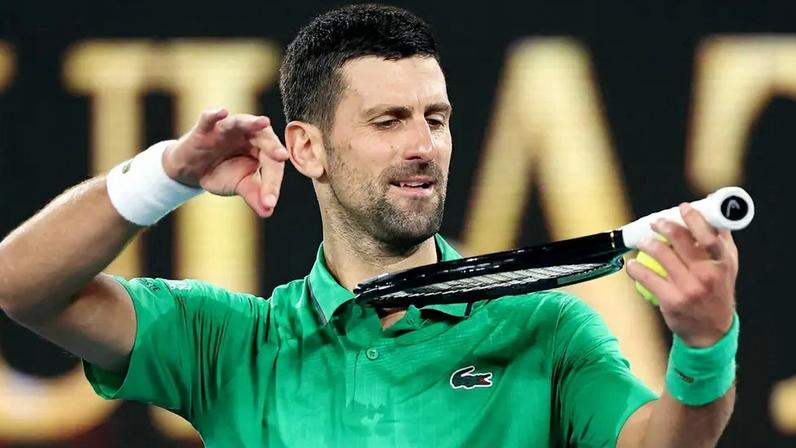 Novak Djokovic imita tocar violino com a raquete ao comemorar a vitória sobre o holandês Botic van de Zandschulp no sétimo dia do Australian Open, em Melbourne, em 24 de janeiro de 2026 (Foto: Martin Keep/AFP)
