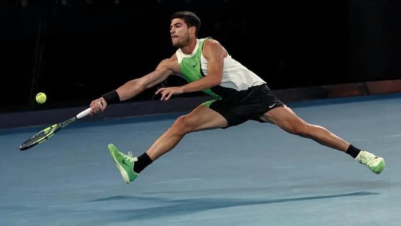 O espanhol Carlos Alcaraz devolve a bola na partida contra o australiano Alex De Minaur no Australian Open (Foto: IZHAR KHAN / AFP)