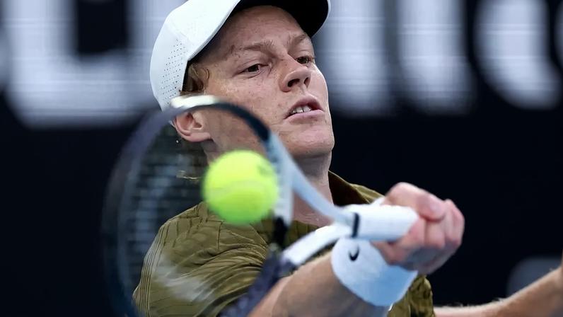 O italiano Jannik Sinner acelera a bola na partida contra o americano Ben Shelton no Australian Open (Foto: IZHAR KHAN / AFP)