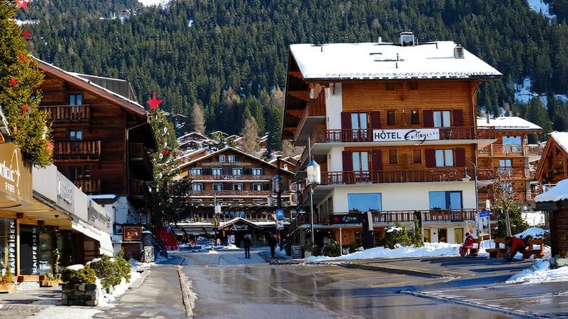 People walk next to a snow covered Verbier Swiss ski resort in Verbier