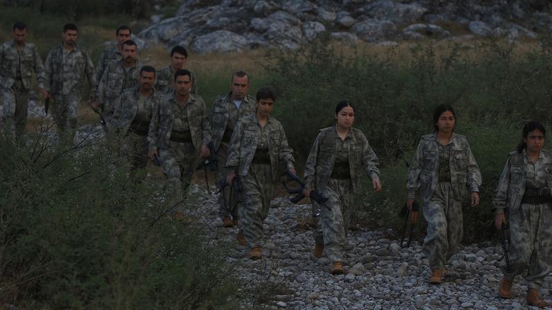 Fighters with the Kurdistan Workers' Party (PKK) walk for a disarmament ceremony marking a significant step toward ending the decades-long conflict between Turkey and the outlawed group, in the Qandil mountains, Iraq October 26, 2025. REUTERS/Thaier Al-Sudani