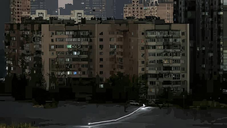 Children use a flashlight as they slide down a snow slope during a power blackout after critical civil infrastructure was hit by Russian missile and drone attacks, amid Russia's attack on Ukraine, in Kyiv, Ukraine January 20, 2026. Picture taken with long exposure.