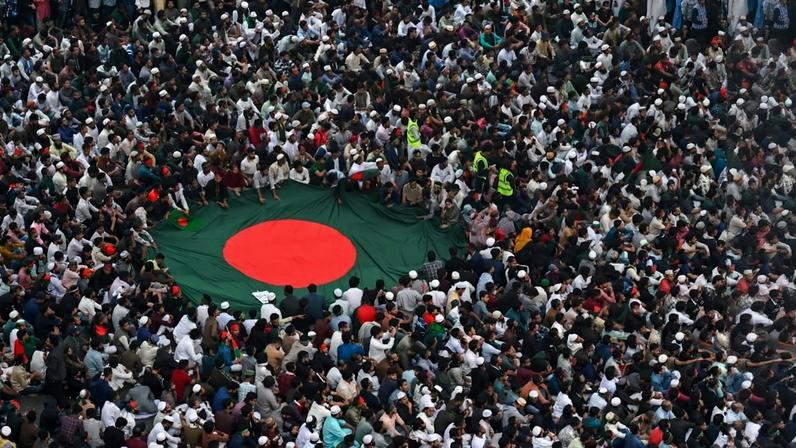 Thousands of people gather and hold Bangladesh’s flag after the funeral ceremony of Sharif Osman Hadi, a student leader, in Dhaka.