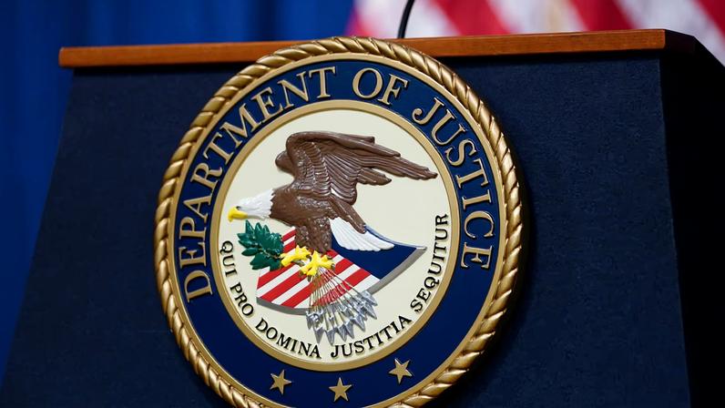 The seal of the U.S. Justice Department is seen on the podium in the Department's headquarters briefing room in Washington