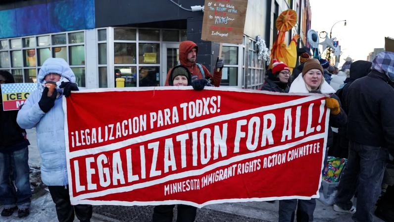 People hold a banner during a demonstration against the presence of federal immigration agents in Minneapolis, Minnesota, U.S., January 28, 2026.