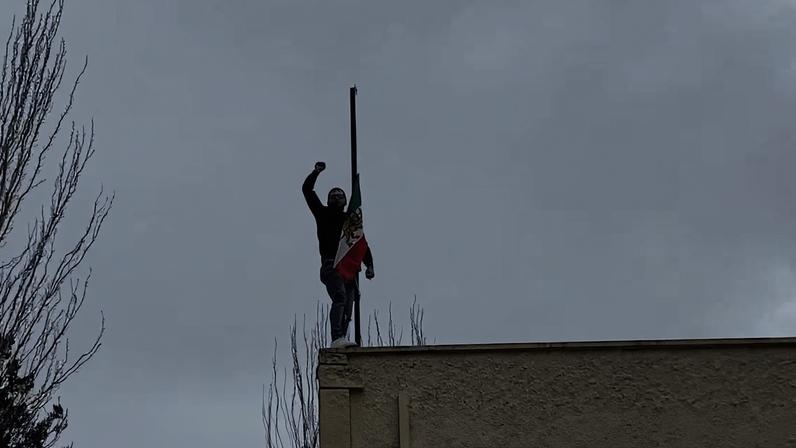 Un activista sustituye la bandera islámica de la embajada de Irán en Madrid por la previa a la revolución de 1979