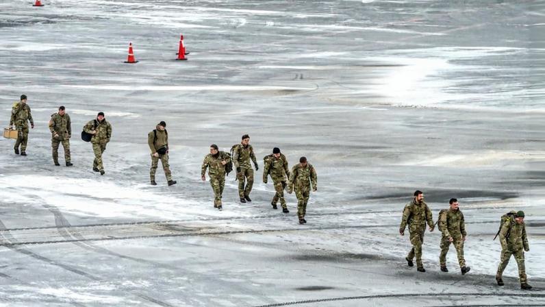 Danish soldiers walk across the frozen tarmac after arriving at Nuuk Airport in Greenland.