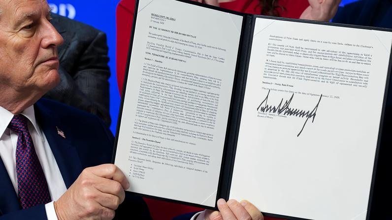 U.S. President Donald Trump holds a signed resolution, as he attends a charter announcement for his Board of Peace initiative aimed at resolving global conflicts, alongside the 56th annual World Economic Forum (WEF), in Davos, Switzerland, January 22, 2026. REUTERS/Jonathan Ernst/File Photo