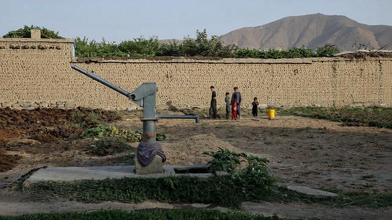 Children stand nearby a dried-up hand-pump, amid serious water crisis in Kabul, Afghanistan, August 29, 2025. REUTERS/Sayed Hassib