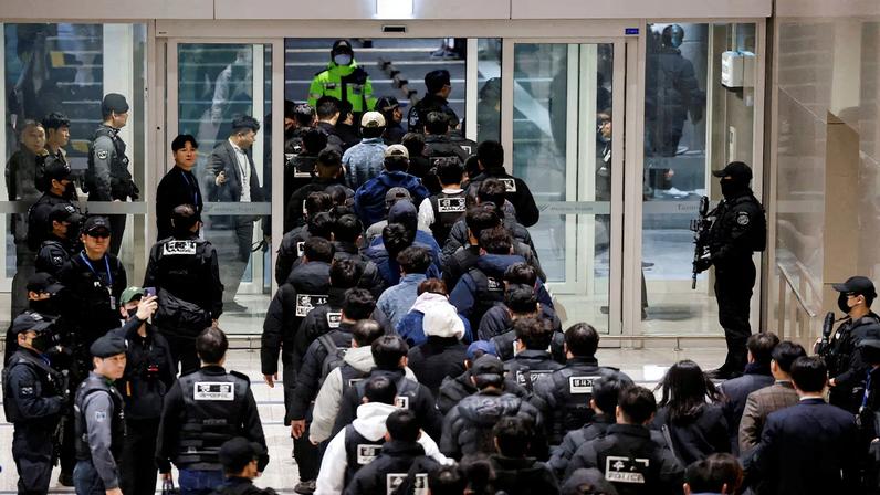 Police officers escort South Koreans allegedly involved in scam operations in Cambodia after being forcibly repatriated from Cambodia, at Incheon International Airport in Incheon, South Korea.