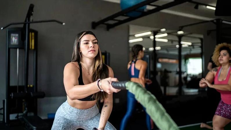 Young woman working out with battle ropes at the gym (Getty Images)