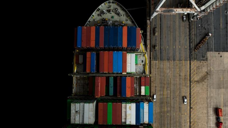 An aerial view shows a cargo ship carrying shipping containers moored to the pier at the Port of Baltimore in Baltimore, Maryland, on April 10, 2025.