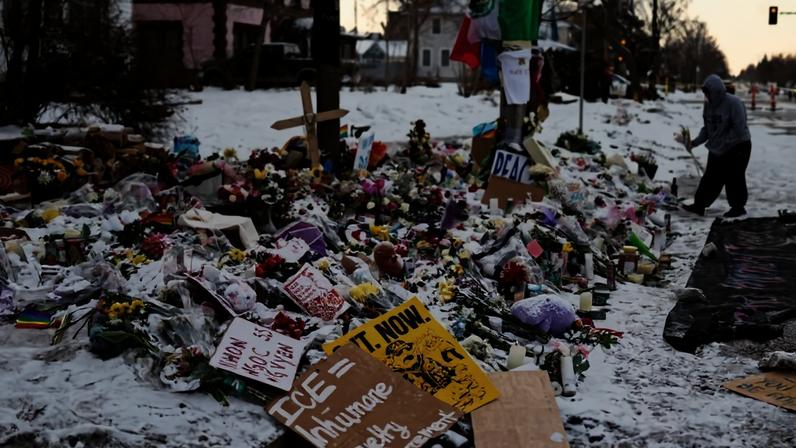 A woman visits a makeshift memorial honoring Renee Nicole Good outside a home on Portland Avenue South in Minneapolis, Minnesota.