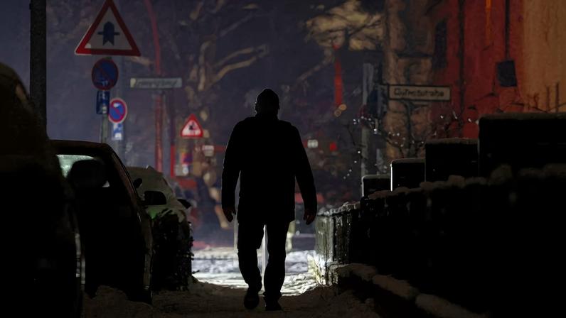 A person walks along a street during a blackout, which left thousands of homes without power after a suspected arson attack at the Lichterfelde power plant in the Steglitz-Zehlendorf district in southern Berlin, Germany, January 6, 2026. REUTERS/Lisi Niesner/File Photo