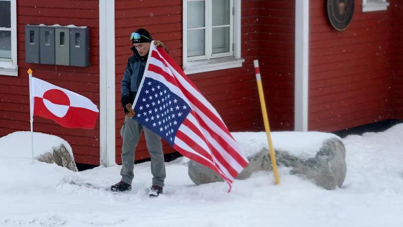 Una persona se manifiesta ante el consulado de Estados Unidos en Nuuk, la capital de Groenlandia, con la bandera de ese país invertida, un gesto utilizado en navegación para alertar de peligro a bordo y que en EE UU también se utiliza como una señal de protesta política