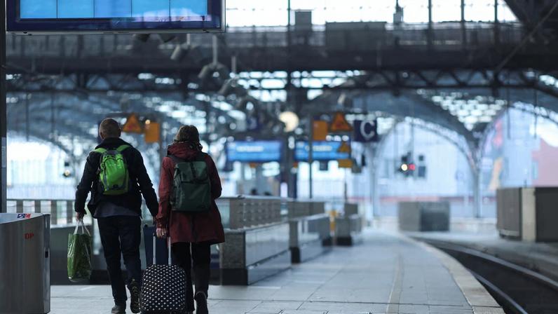 People walk on the platform of the empty Cologne Central Station in Cologne, Germany, April 21, 2023. REUTERS/Thilo Schmuelgen/File Photo