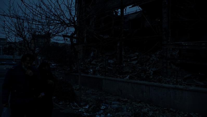 People pass by a destroyed building on Jan. 10, 2026 in Tehran, Iran.