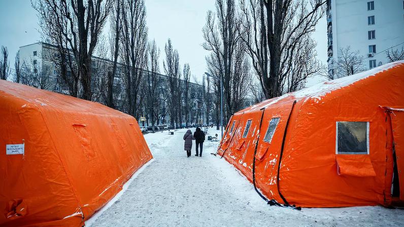 People pass by a Point of Invincibility center, a government-run shelter which offers basic services and heat during blackouts, where residents warm up and charge their devices, during power cut-offs after critical civil infrastructure was hit by recent Russian missile and drone strikes, amid Russia's attack on Ukraine, in Kyiv, Ukraine, January 23, 2026. REUTERS/Alina Smutko