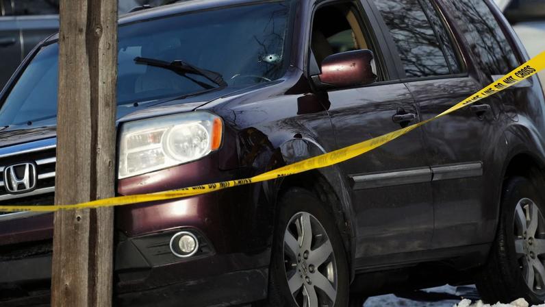 Police tape is seen around a vehicle with a bullet hole the windshield after a driver was shot in Minneapolis