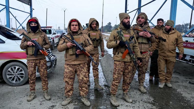 Members of the Syrian military police gather outside al-Aqtan prison, where some Islamic State detainees are held, in Raqqa
