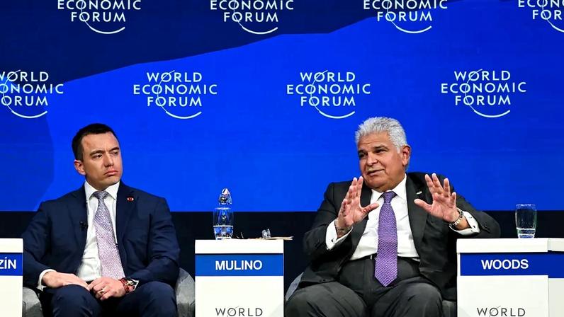 Ecuadoran President Daniel Noboa and Panamanian President Jose Raul Mulino sit during a panel at the World Economic Forum annual meeting in Davos, Switzerland. Behind them is a blue background with World Economic Forum logos.