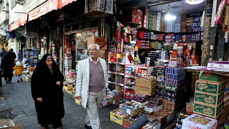 People walk on a street, as protests erupt over the collapse of the currency's value, in Tehran