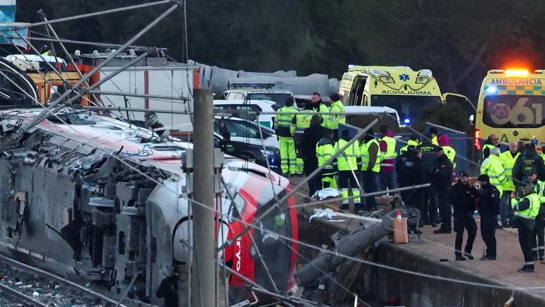Members of the Spanish Civil Guard, along with other emergency personnel, work next to one of the trains involved in the accident, at the site of a deadly derailment of two high-speed trains near Adamuz, in Cordoba, Spain, January 19, 2026. REUTERS/Susana Vera