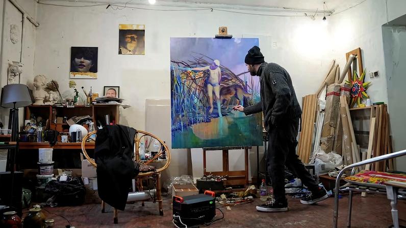 Ukrainian artist works at his studio during a power blackout in Kyiv