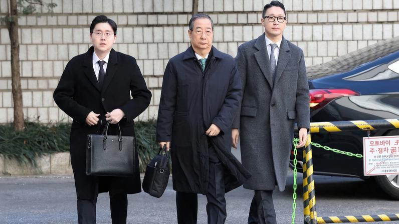 SEOUL, SOUTH KOREA - JANUARY 21: Former South Korean Prime Minister Han Duck-soo (C) arrives at the Seoul Central District Court for his first sentencing trial in the insurrection case on January 21, 2026 in Seoul, South Korea. Chung Sung-Jun/Pool via REUTERS