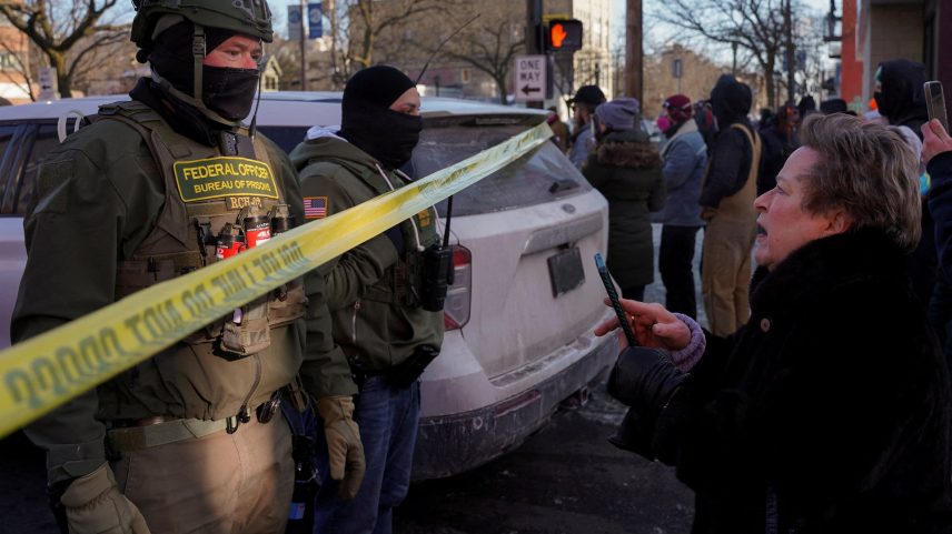 Federal agents stand behind police tape as people gather near the site where a man identified as Alex Pretti was fatally shot by federal agents trying to detain him, in Minneapolis, Minnesota, U.S., January 24, 2026. REUTERS/Seth Herald/File Photo