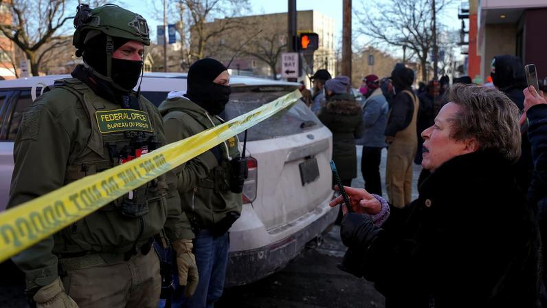Federal agents stand behind police tape as people gather near the site where a man identified as Alex Pretti was fatally shot by federal agents trying to detain him, in Minneapolis, Minnesota, U.S., January 24, 2026. REUTERS/Seth Herald/File Photo