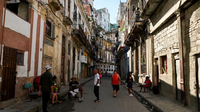 People spend time on a street sidewalk, as U.S.-Cuba tensions rise after U.S. President Donald Trump vowed to stop Venezuelan oil and money from reaching Cuba and suggested the communist-run island strike a deal with Washington, in Havana, Cuba, January 11, 2026. REUTERS/Norlys Perez