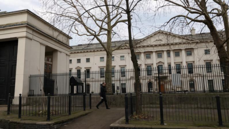 A man walks past Royal Mint Court, the proposed site of China's planned mega‑embassy, after the government approved China's application to redevelop the former Royal Mint site in east London, Britain, January 20, 2026. REUTERS/Jack Taylor