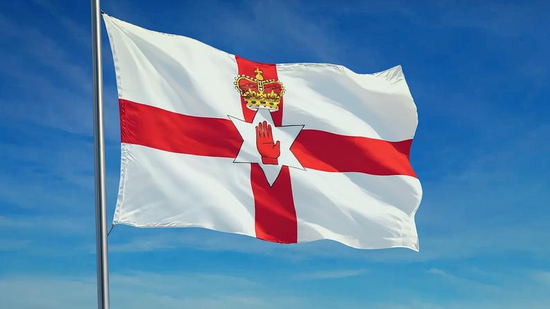 Imagem da bandeira da Irlanda do Norte tremulando ao vento.
