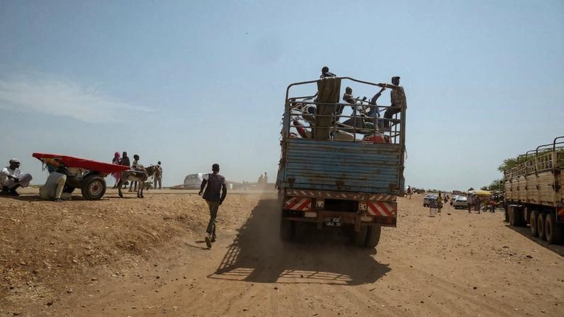 A person is shown from behind, running toward a truck filled with people.