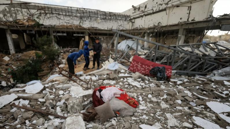 Palestinians inspect the damage at the site of a war-damaged building after parts of it collapsed, on a windy winter day, in Gaza City, January 13, 2026. REUTERS/Dawoud Abu Alkas