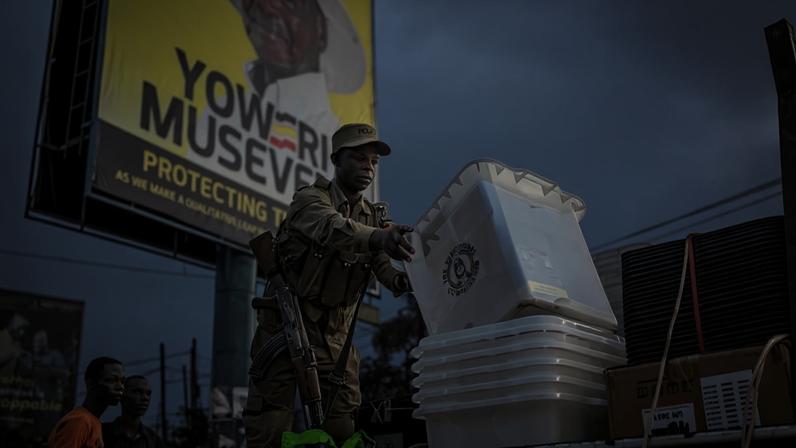 An Ugandan police officer unloads ballot boxes from a truck at a polling station in Kampala, Uganda, on Jan. 15.