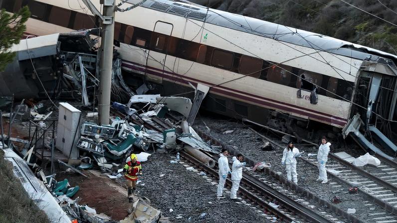 A firefighter and members of the Spanish Civil Guard work next to one of the trains involved in the accident, at the site of a deadly derailment of two high-speed trains near Adamuz, in Cordoba, Spain, January 19, 2026. REUTERS/Susana Vera