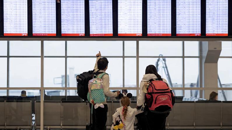 People check the flight tracker screens at the Dallas Fort Worth International Airport in Fort Worth, Texas, U.S., January 23, 2026. REUTERS/Alyssa Pointer