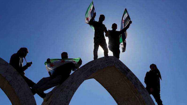 People hold flags as they celebrate, after Syria and the main Kurdish fighting force SDF struck a wide-ranging deal to bring Kurdish civilian and military authorities under central government control on Sunday, ending days of fighting in which Syrian troops captured territory including key oil fields, in Raqqa, Syria January 19, 2026.