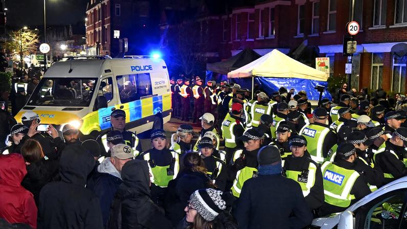 People stand in front of police officers near a Kurdish community centre after a counter terrorism investigation into suspected activity linked to the banned Kurdistan Workers Party, known as the PKK, in London, Britain, November 27, 2024. REUTERS/Jaimi Joy/File Photo