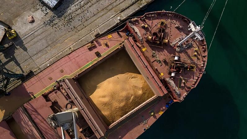 Carregamento de soja em navio graneleiro em área portuária