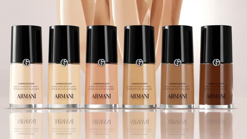 Six bottles of Armani Beauty Luminous Silk foundation in varying shades from light to dark.