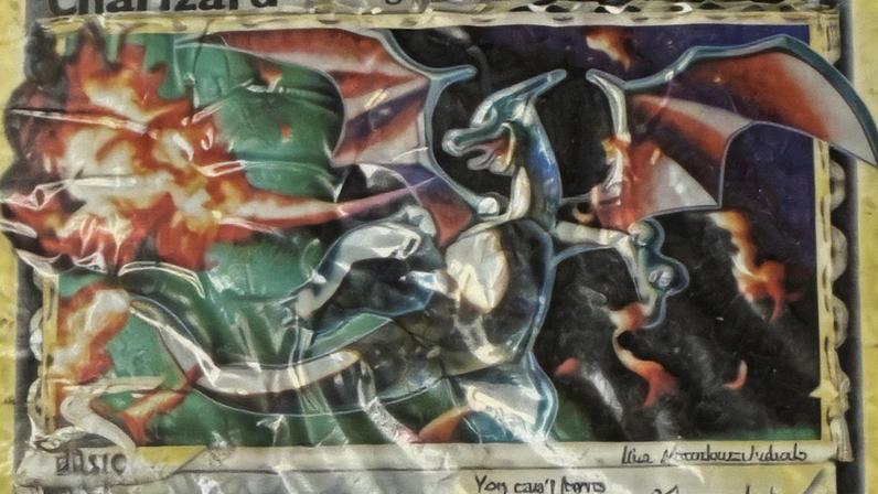 The front and back of the ruined Charizard gold star card.