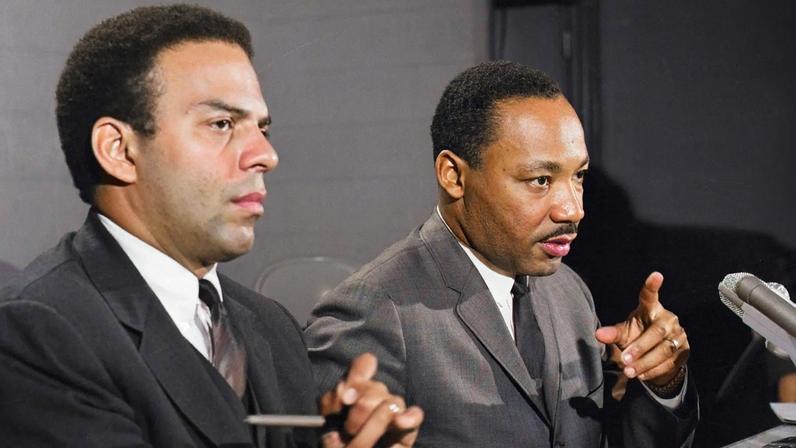 Dr. Martin Luther King Jr. at a press conference accompanied by his aide Reverend Andrew Young.