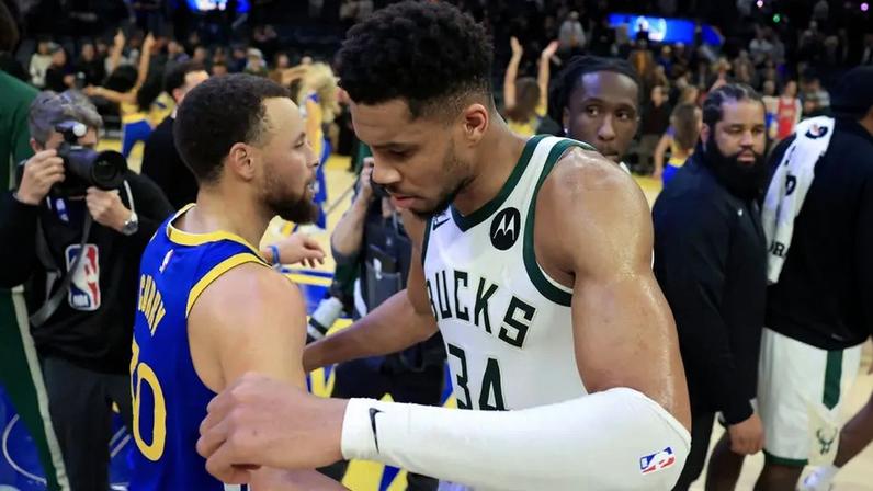 Giannis Antetokounmpo e Stephen Curry se cumprimentam em jogo entre Warriors e Bucks na NBA (Foto: Ezra Shaw / Getty Images / AFP)